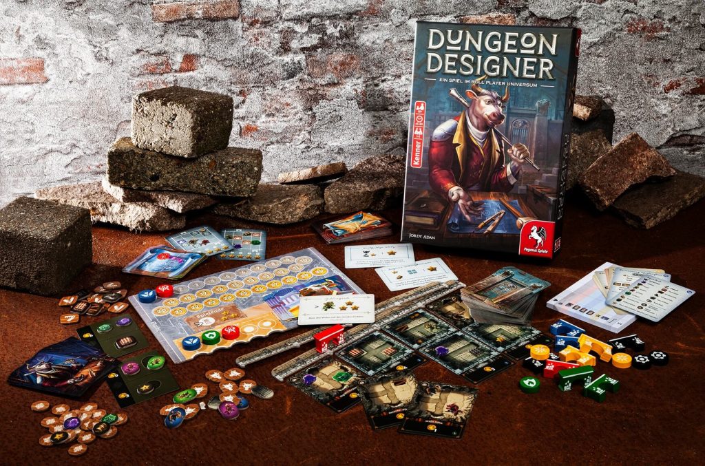 Ausgebreitetes Spielmaterial und Schachtel des Brettspiels Dungeon Designer