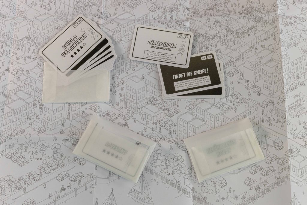 Spielkarte und Fallkarten des Brettspiels Micro Macro: Crime City