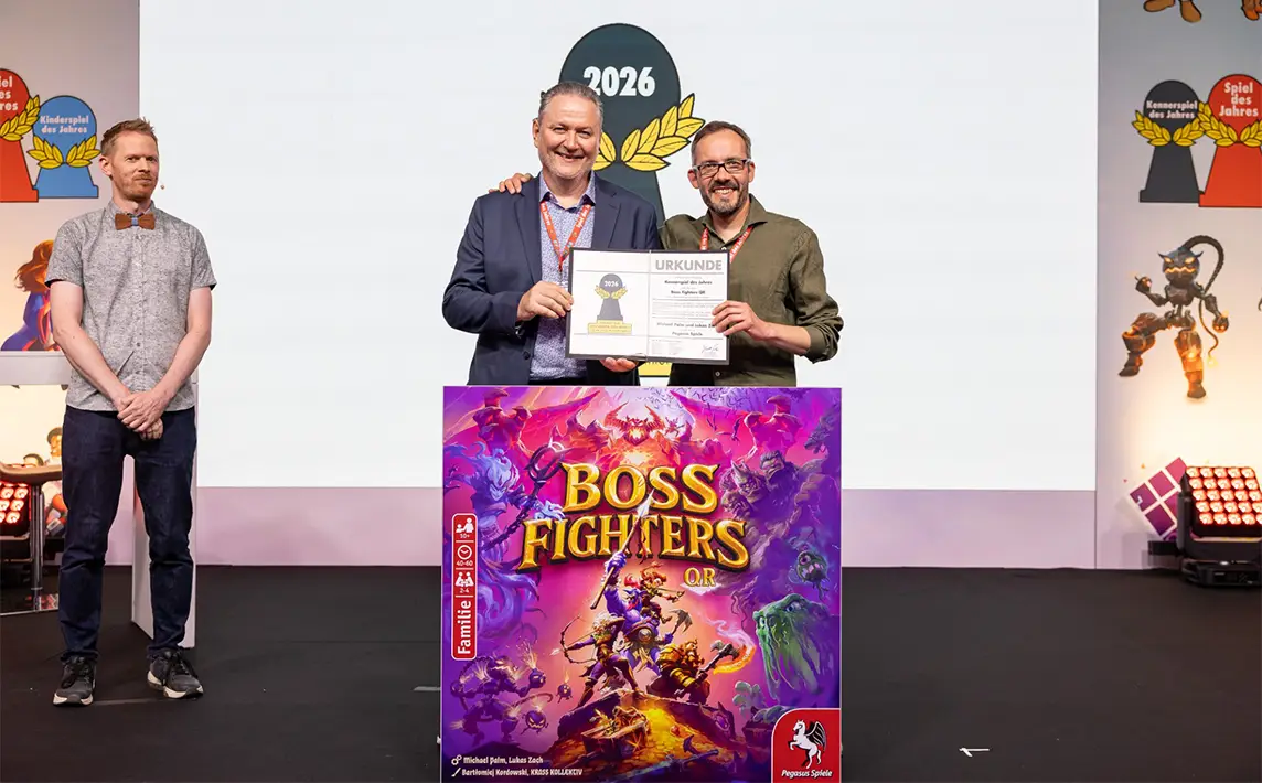Michael Palm und Lukas Zach mit der Nominierungsurkunde für Boss Fighters QR bei der Spiel-des-Jahres-Verleihung 2026